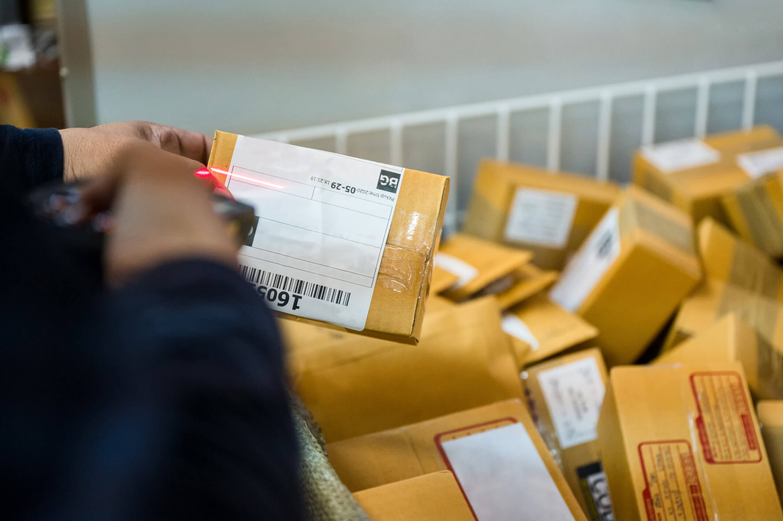 delivery man using laser scanner to scan packages