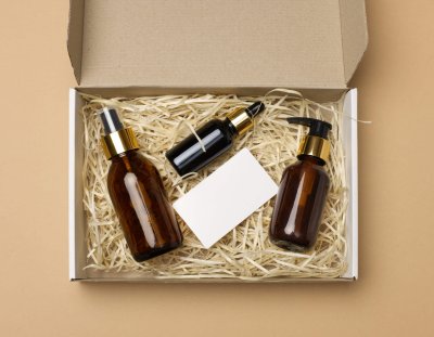 brown glass bottles for cosmetics and a white paper blank busine fragile cosmetic items in package with protective filling