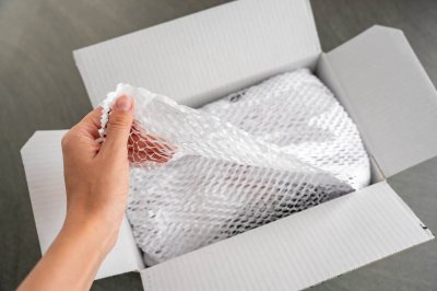 Corrugated white paper for safe transportation, in which the goods brought by the courier delivery service are wrapped, environmental packaging concept Corrugated white paper for safe transportation, in which the goods brought by the courier delivery service are wrapped, environmental packaging concept. High quality photo