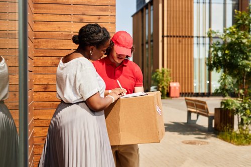 Receiving Delivery Package from Courier in Street Setting woman signing for a package delivery